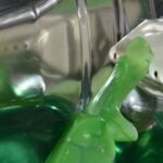 Aqua Spin - Closeup of green liquid detergent in pure water inside drum of washing machine