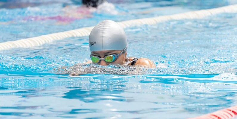 Solo Swimmers - A swimmer in a pool with goggles on