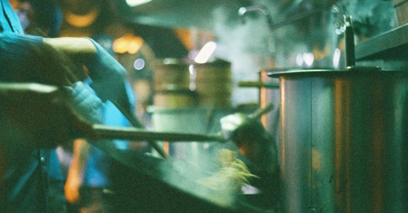 Pool Noodles - A man in a kitchen cooking food in a restaurant