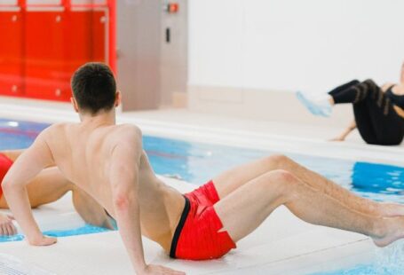 Water Aerobics - People Exercising on Floating Boards in a Swimming Pool