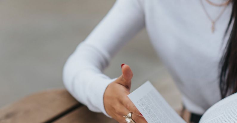 Flip Turn - Serious woman reading book at table in street cafe