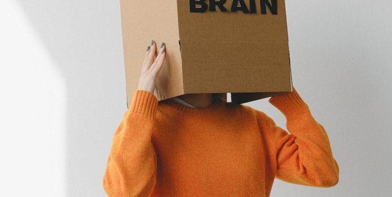 Lung Capacity - Crop person putting Idea title in cardboard box with Brain inscription on head of female on light background