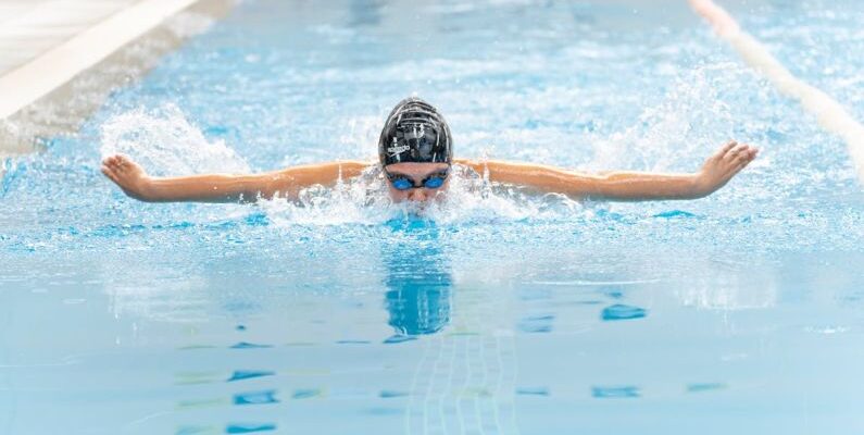 Swim Training - A swimmer in the pool with her arms outstretched