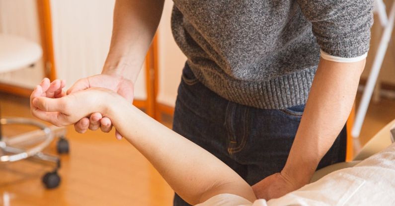 Shoulder Injury - Crop chiropractor massaging hand of patient