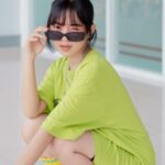 Tempo Trainers - A woman in a green shirt and sunglasses squatting