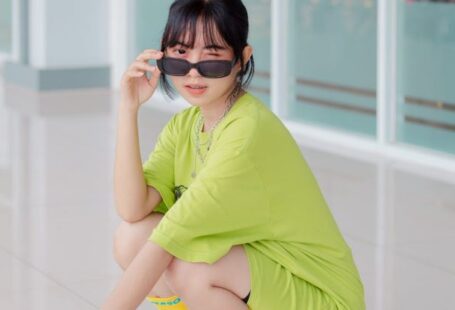 Tempo Trainers - A woman in a green shirt and sunglasses squatting