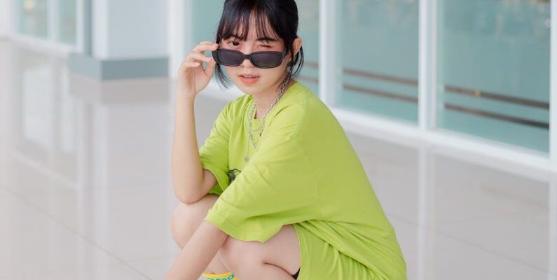 Tempo Trainers - A woman in a green shirt and sunglasses squatting