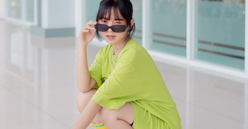 Tempo Trainers - A woman in a green shirt and sunglasses squatting