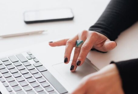 Tapering Strategies - Crop female using touchpad on laptop in office