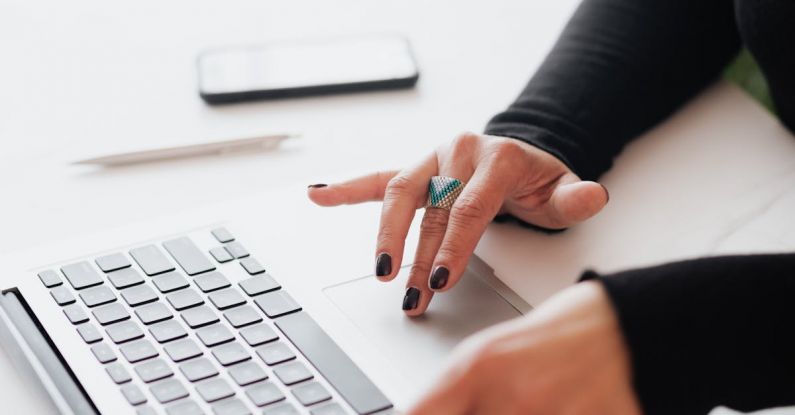 Tapering Strategies - Crop female using touchpad on laptop in office