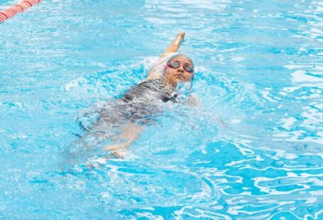 Backstroke - A woman swimming in a pool with a red line