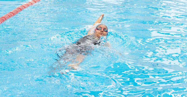 Backstroke - A woman swimming in a pool with a red line