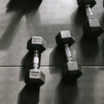 Periodization Training - Dumbbells on a tiled floor in a gym