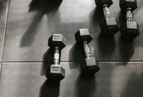 Periodization Training - Dumbbells on a tiled floor in a gym