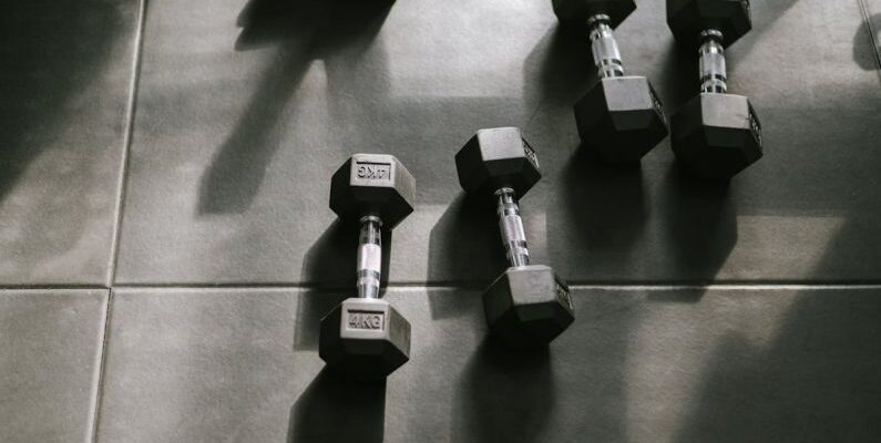 Periodization Training - Dumbbells on a tiled floor in a gym