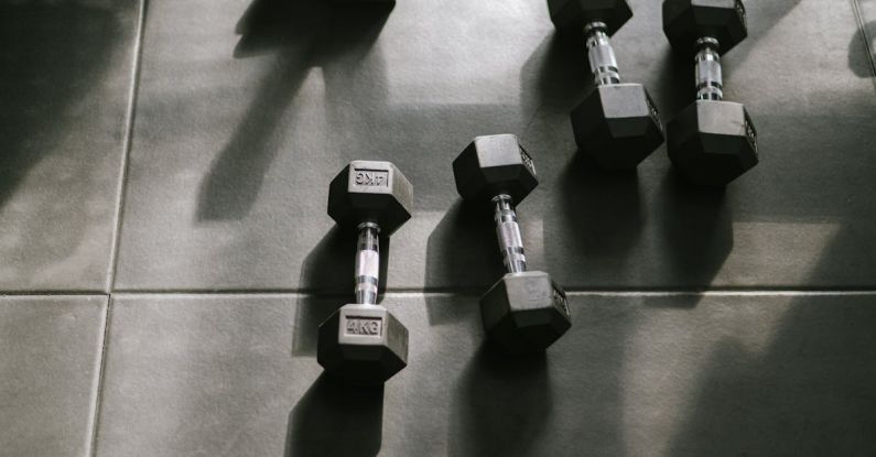 Periodization Training - Dumbbells on a tiled floor in a gym