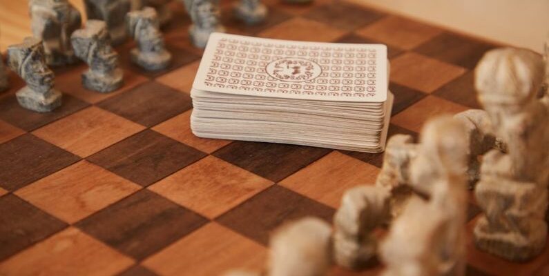 Mental Strategies - Chessboard with chess pieces and game of cards