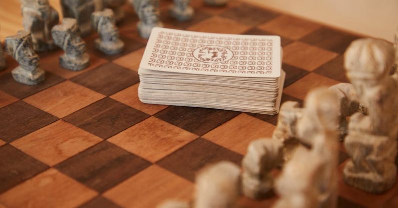 Mental Strategies - Chessboard with chess pieces and game of cards