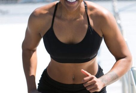 Core Muscles - Woman Wearing Black Sports Bra and Jogger Shorts Smiling