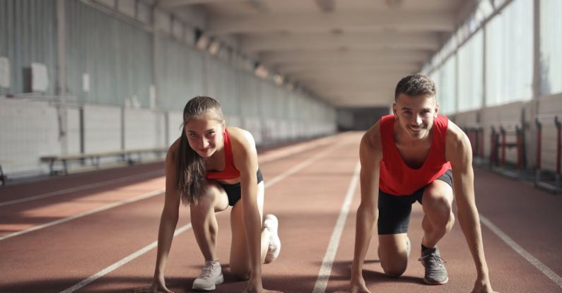 Transition Skills - Men and Woman in Red Tank Top is Ready to Run on Track Field