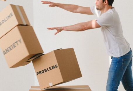 Hydrostatic Pressure - Full body of young man in sneakers and jeans pushing and falling boxes saying Work Problems Anxiety Stress and Deadline while fighting with problems