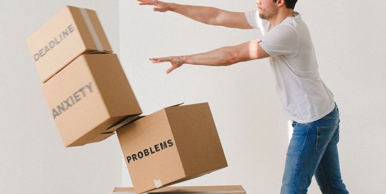 Hydrostatic Pressure - Full body of young man in sneakers and jeans pushing and falling boxes saying Work Problems Anxiety Stress and Deadline while fighting with problems