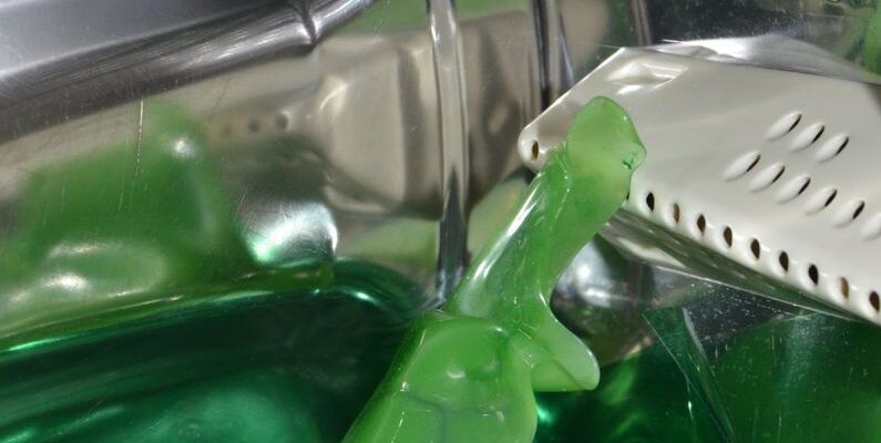 Aqua Spin - Closeup of green liquid detergent in pure water inside drum of washing machine