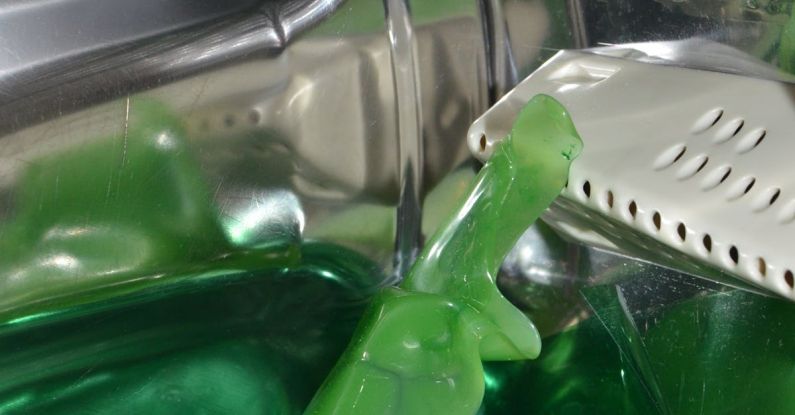 Aqua Spin - Closeup of green liquid detergent in pure water inside drum of washing machine